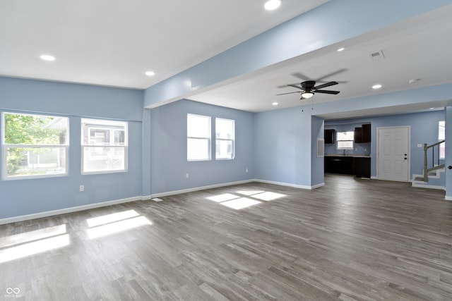 unfurnished living room with dark hardwood / wood-style floors, plenty of natural light, and ceiling fan