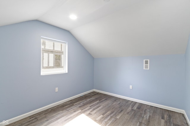 additional living space featuring dark hardwood / wood-style flooring and lofted ceiling