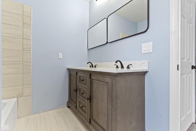 bathroom featuring a washtub and vanity