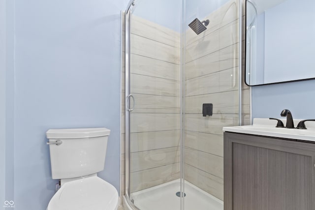 bathroom featuring an enclosed shower, vanity, and toilet