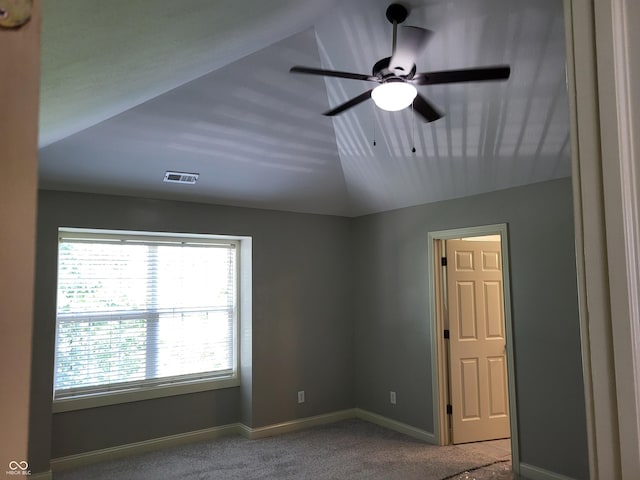 carpeted empty room with vaulted ceiling and ceiling fan