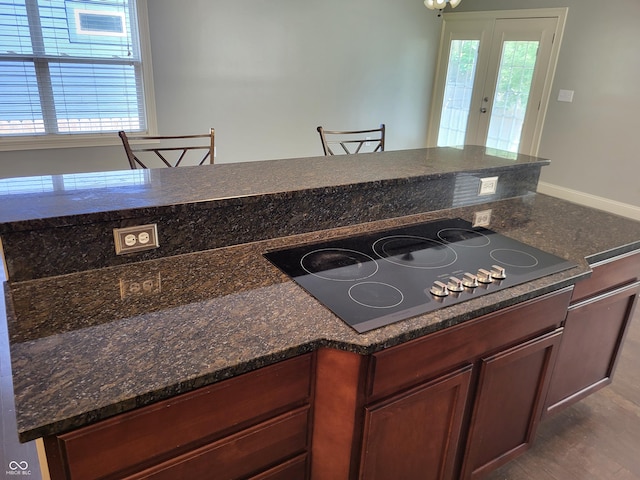 kitchen with stovetop, a wealth of natural light, and a breakfast bar