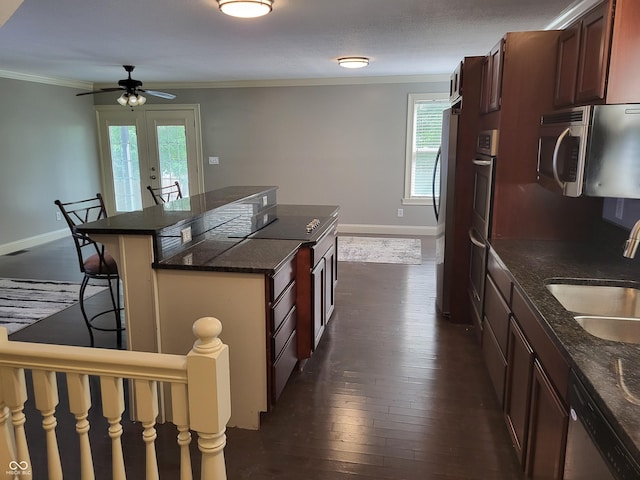 kitchen featuring sink, crown molding, a breakfast bar, appliances with stainless steel finishes, and plenty of natural light