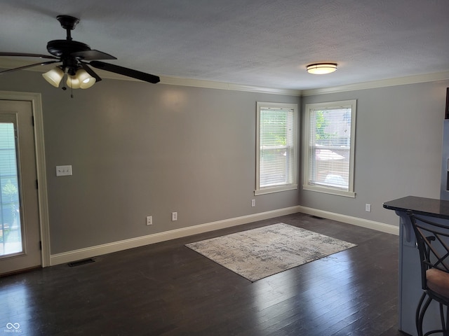 interior space featuring dark hardwood / wood-style flooring, ornamental molding, and a healthy amount of sunlight