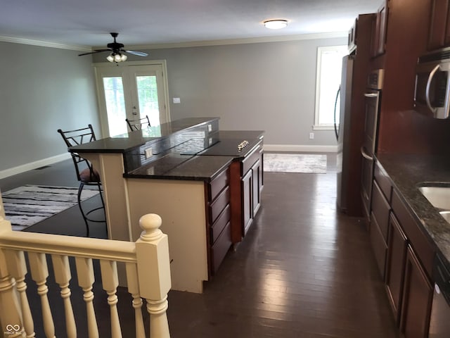 kitchen featuring crown molding, a breakfast bar, stainless steel appliances, a center island, and dark hardwood / wood-style flooring