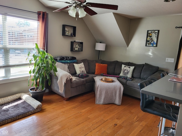 living room featuring vaulted ceiling, a healthy amount of sunlight, ceiling fan, and light hardwood / wood-style flooring