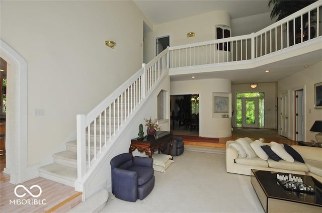 living room with hardwood / wood-style floors and a towering ceiling