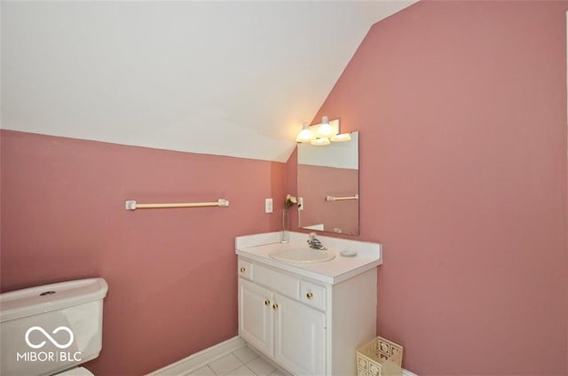 bathroom featuring tile patterned flooring, vanity, toilet, and lofted ceiling