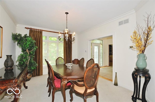 carpeted dining area featuring ornamental molding and an inviting chandelier