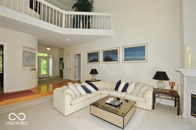 living room with a fireplace and a high ceiling