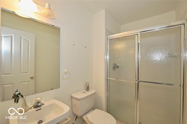 bathroom with toilet, walk in shower, and sink