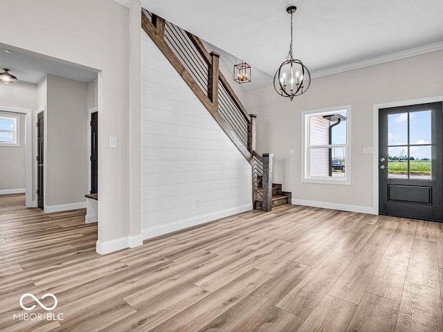 entrance foyer with a chandelier, light hardwood / wood-style floors, and crown molding