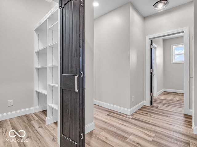 hallway with light hardwood / wood-style floors