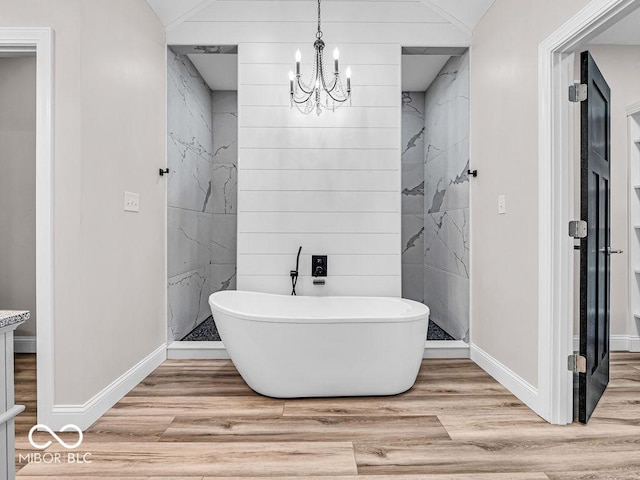 bathroom featuring a bathing tub, vaulted ceiling, wood-type flooring, and a chandelier