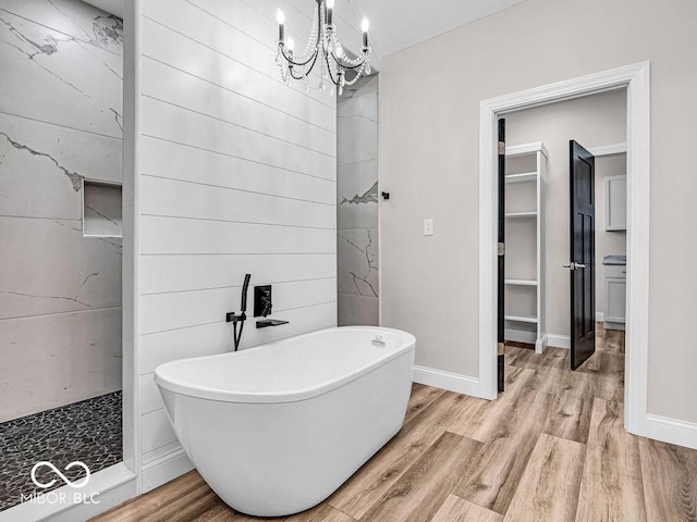 bathroom with hardwood / wood-style floors, an inviting chandelier, and independent shower and bath