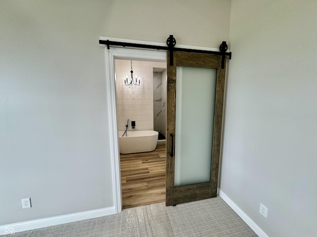 bathroom featuring tile patterned flooring, a bathtub, and a notable chandelier