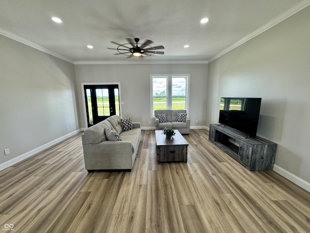 living room with crown molding, ceiling fan, and light hardwood / wood-style floors