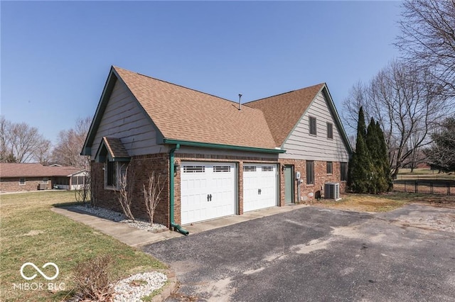 view of property exterior with a lawn, central AC unit, and a garage