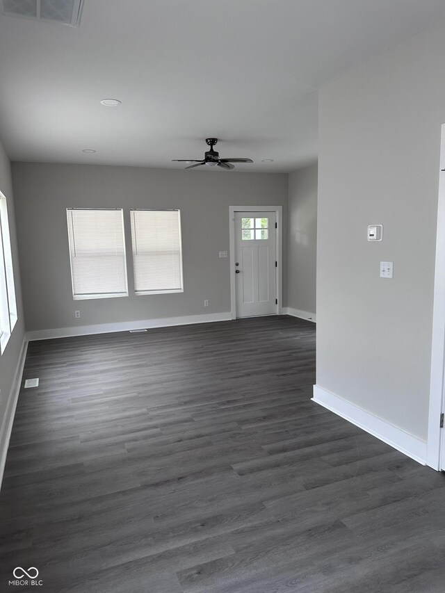 interior space with dark wood-type flooring and ceiling fan