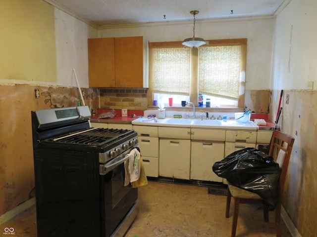 kitchen featuring crown molding, sink, decorative light fixtures, and stainless steel range with gas stovetop