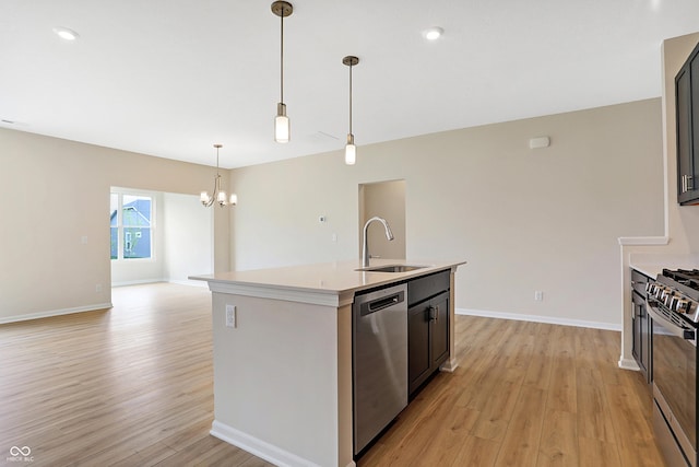 kitchen with a kitchen island with sink, sink, light hardwood / wood-style flooring, appliances with stainless steel finishes, and decorative light fixtures