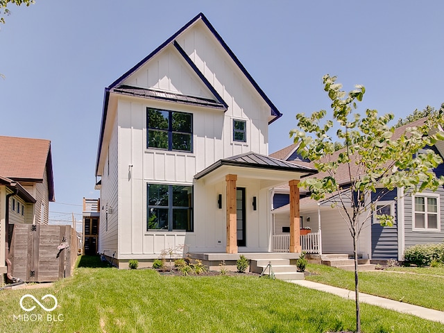 modern inspired farmhouse featuring metal roof, covered porch, board and batten siding, a standing seam roof, and a front yard