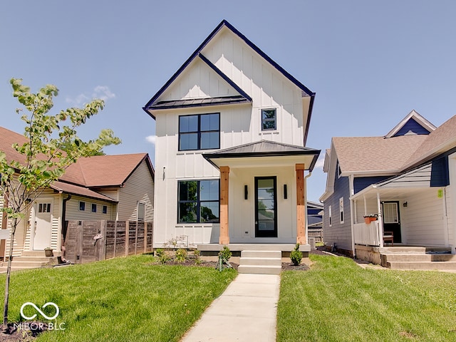 modern farmhouse featuring metal roof, a standing seam roof, covered porch, board and batten siding, and a front yard