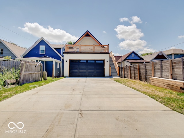 view of front facade featuring a garage, concrete driveway, and fence