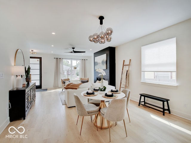 dining area featuring light wood-style floors, recessed lighting, baseboards, and an inviting chandelier