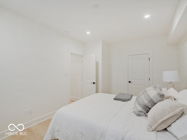 bedroom featuring light wood finished floors, baseboards, and recessed lighting