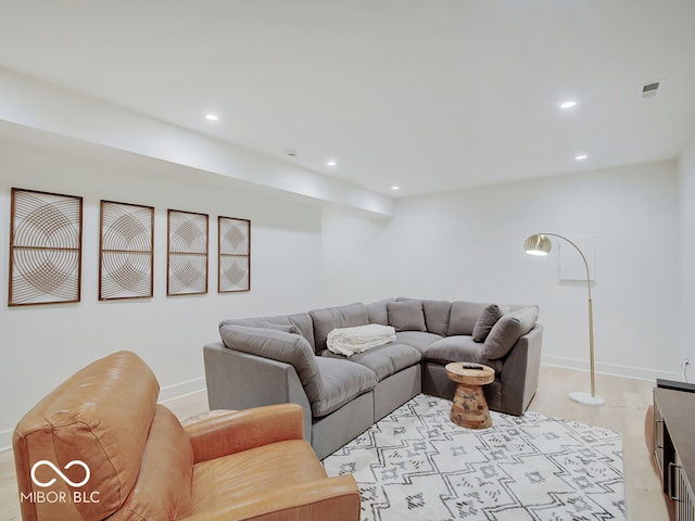 living room featuring baseboards, light wood-style flooring, visible vents, and recessed lighting