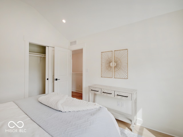 bedroom with visible vents, light wood-style flooring, vaulted ceiling, a closet, and recessed lighting