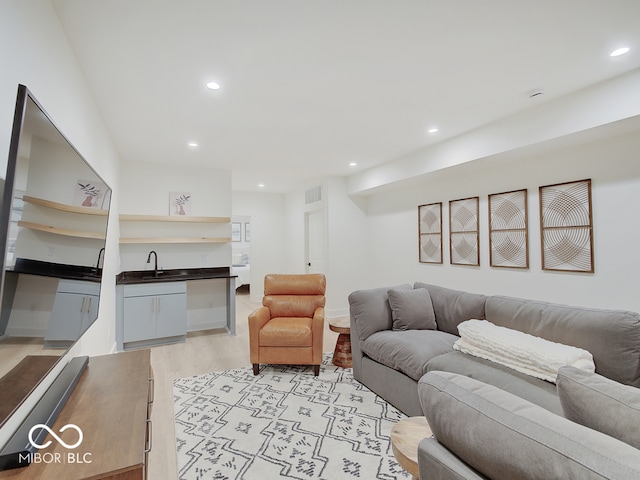 living area featuring light wood finished floors, visible vents, and recessed lighting