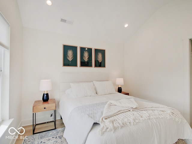 bedroom with lofted ceiling, visible vents, wood finished floors, and recessed lighting