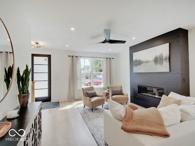 living room with recessed lighting, a large fireplace, ceiling fan, and wood finished floors