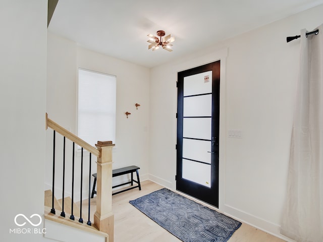 entryway featuring stairs, baseboards, and wood finished floors