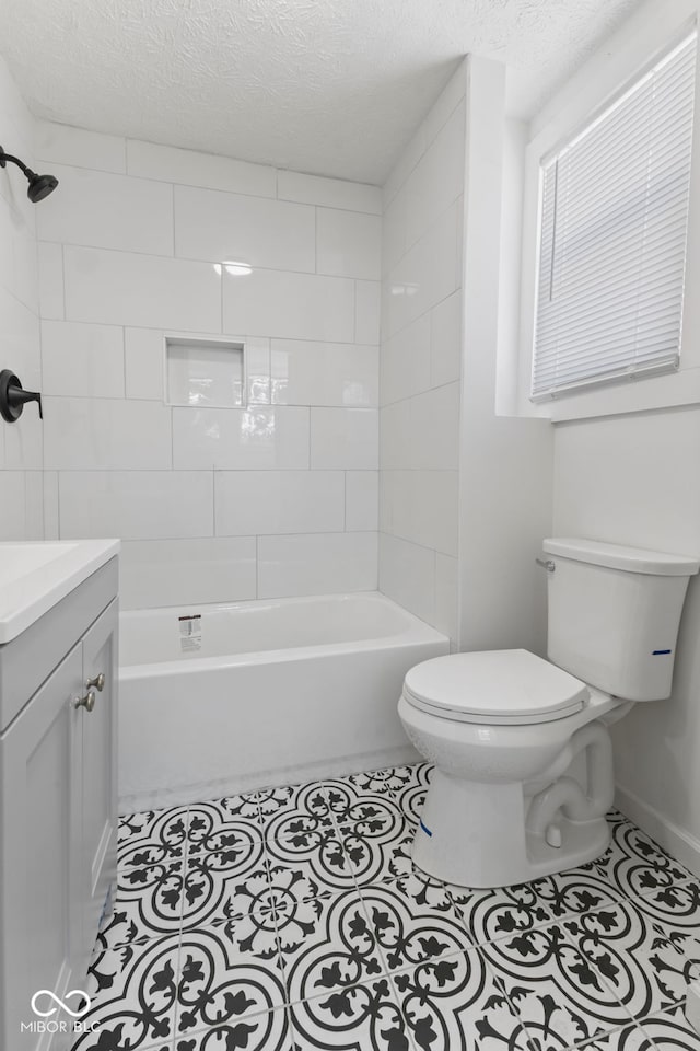 full bathroom with a textured ceiling, toilet, vanity,  shower combination, and tile patterned floors