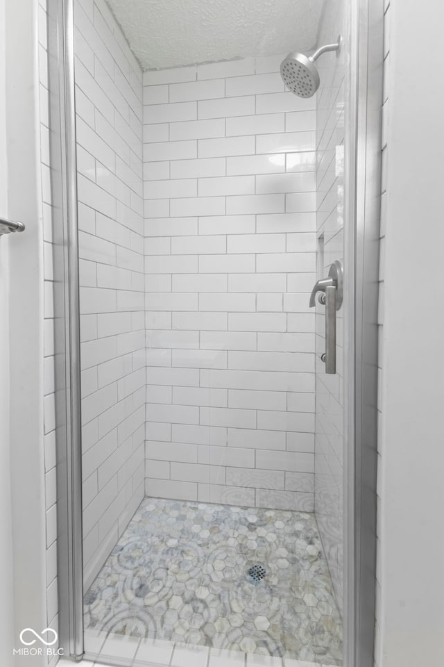 bathroom featuring a textured ceiling and walk in shower