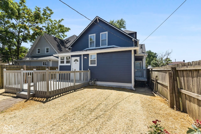 rear view of house featuring a fenced backyard and a wooden deck