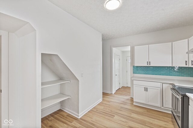 kitchen with electric range, light wood-type flooring, and white cabinetry