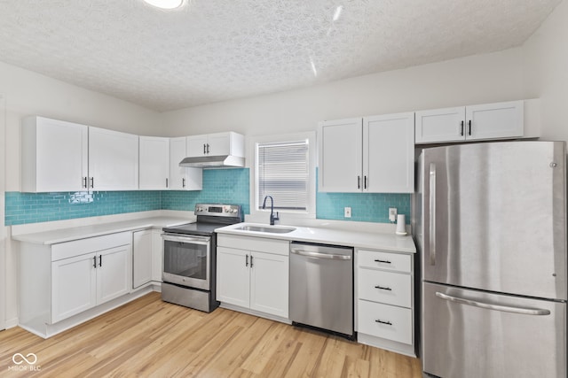 kitchen featuring light wood-type flooring, white cabinets, stainless steel appliances, and sink