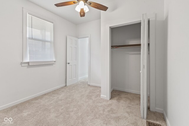 unfurnished bedroom with a closet, ceiling fan, and light colored carpet