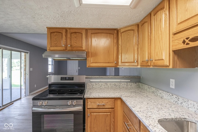 kitchen featuring hardwood / wood-style flooring, light stone countertops, a textured ceiling, and stainless steel range with electric cooktop