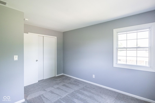 unfurnished bedroom with a closet and carpet floors