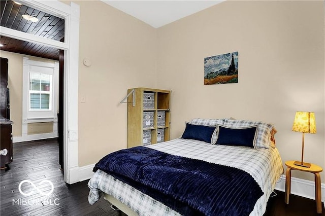 bedroom with wooden ceiling, beamed ceiling, and dark wood-type flooring