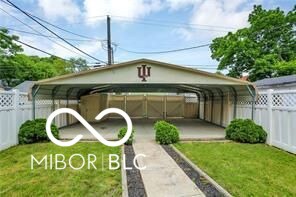 view of outdoor structure with a carport and a yard