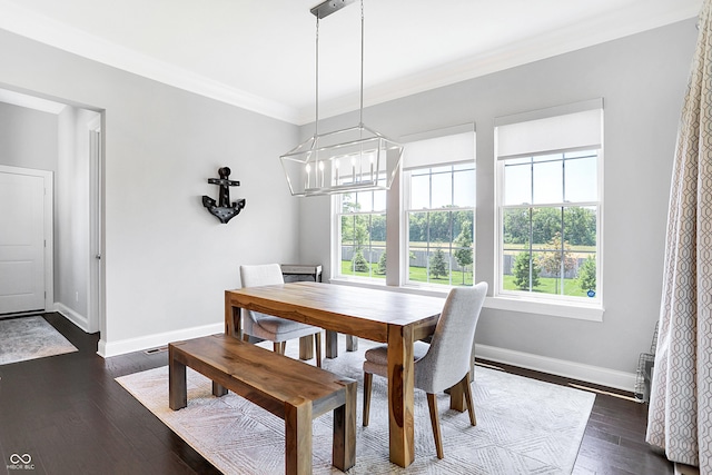 dining space featuring a notable chandelier, baseboards, dark wood finished floors, and crown molding