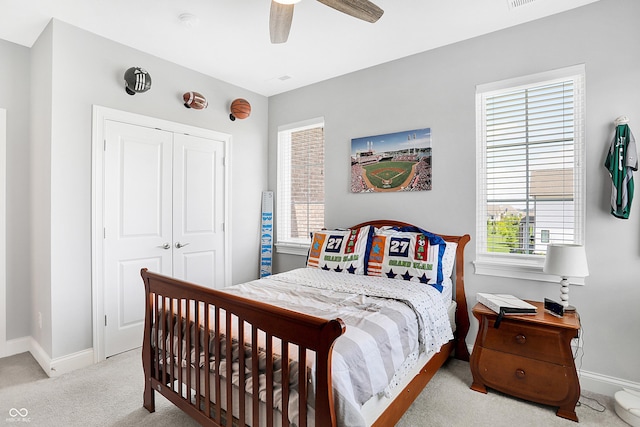 carpeted bedroom featuring a ceiling fan, a closet, visible vents, and baseboards