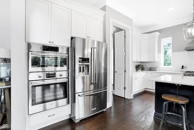 kitchen featuring stainless steel appliances, white cabinetry, dark wood-style floors, and tasteful backsplash