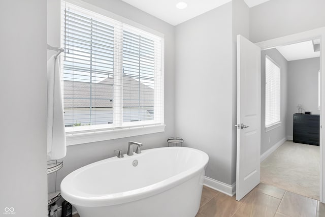 bathroom featuring a freestanding bath and baseboards